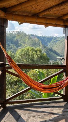 a hammock on a porch with a view of the mountains at Cabaña entre cafetales en Salento in Salento