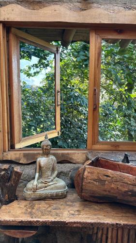 a statue sitting on a table in front of a window at Cabaña entre cafetales en Salento in Salento