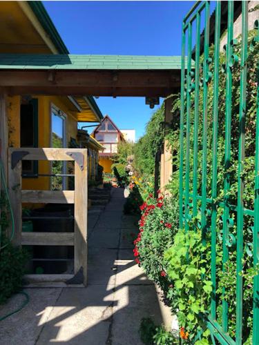 a green fence with flowers next to a house at Hotel de los Castillos in Puerto Natales