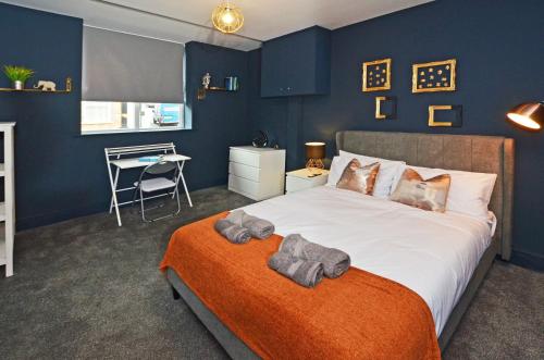 a bedroom with a large bed with an orange blanket at Townhouse PLUS @ London Road Stoke in Stoke on Trent