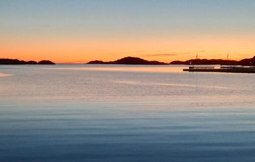a sunset over the water with a dock at Beautiful Apartment In Skärhamn in Skärhamn