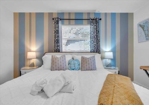 a bedroom with a white bed with pillows and a window at 3BR Sunshine Retreat with Heated Pool, Cold Plunge and Games in Bradenton