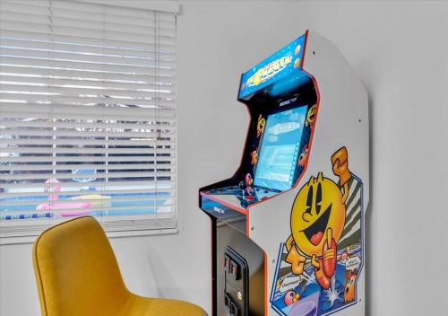 a video game machine with a yellow chair next to it at 3BR Sunshine Retreat with Heated Pool, Cold Plunge and Games in Bradenton