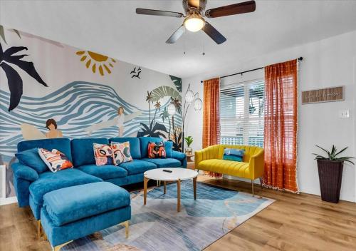 a living room with a blue couch and a yellow chair at 3BR Sunshine Retreat with Heated Pool, Cold Plunge and Games in Bradenton