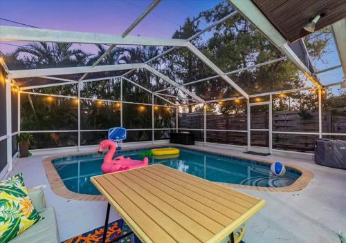a pool with a wooden table and a rubber duck toy at 3BR Sunshine Retreat with Heated Pool, Cold Plunge and Games in Bradenton