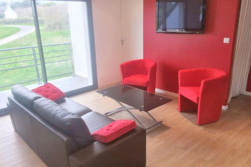 - un salon avec un canapé et deux fauteuils rouges dans l'établissement Appartement confortable à Lamballe avec vue sur mer, à Lamballe