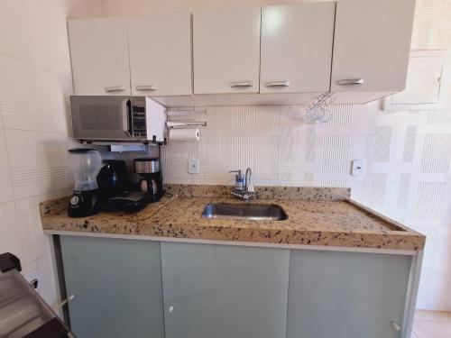 a kitchen counter with a sink and a microwave at Linda Casa Linear Com PISCINA, Buzios in Buzios