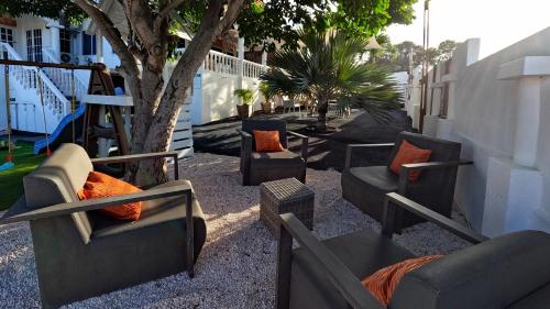 a group of couches and chairs sitting next to a tree at 4BlessingsCuracao2 in Willemstad