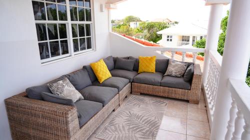 a patio with a couch on a balcony at 4BlessingsCuracao2 in Willemstad