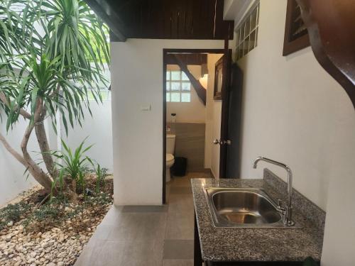 una cocina con fregadero y una palmera en Amara - Luxury Infinity Pool Villa with Sea view, en Surin Beach