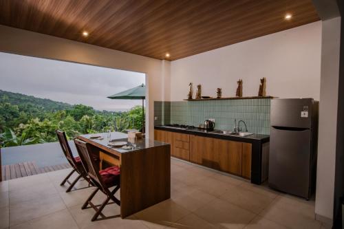 a kitchen with a table and a counter with a view at Abinawa Hill in Lovina