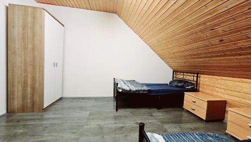 a room with a bed and a wooden ceiling at Ferienhaus Adler in Unterlüß