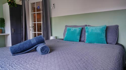a bed with a blue blanket and blue pillows at 4BlessingsCuracao2 in Willemstad