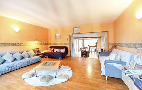 un salon avec des canapés bleus et une table dans l'établissement 3 Bedroom Nice Home In Ault, à Ault