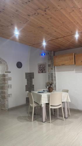 a table and chairs in a room with a wooden ceiling at Casa vacanze Piazza Immacolata in Molfetta
