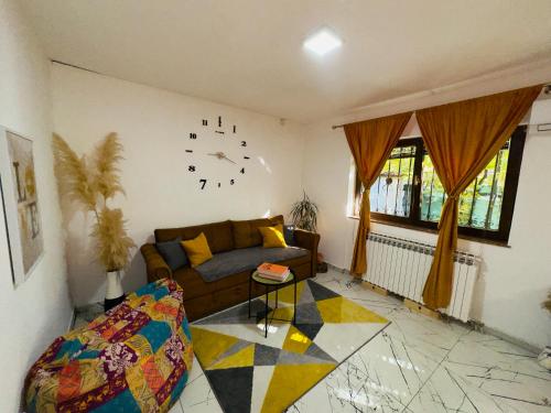 a living room with a couch and a clock on the wall at Hedonist Spa Jacuzzi Sarajevo Free parking in Sarajevo