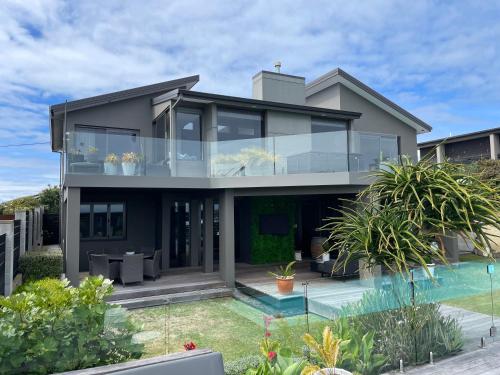 an image of a house with a swimming pool at Luxury 2 Bdrm Ground Level Apt with Private Pool located on Scarborough Hill Sumner Christchurch in Christchurch
