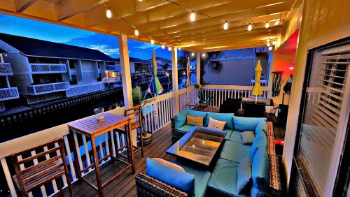 a balcony with a couch and a table and chairs at Boathouse Condo, Downtown Destin Harbor, Private Beach Access, Waterfront, on Golf course, Water Taxi pickup in Destin