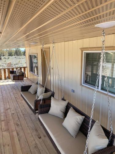 a porch with three swing beds in a house at Zion to Bryce cowboy cabin in Hatch