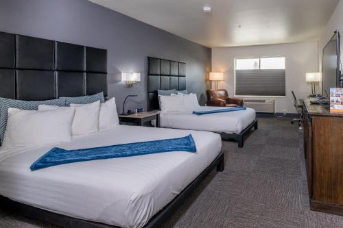 a hotel room with two beds and a desk at Wood River Inn & Suite in Hailey