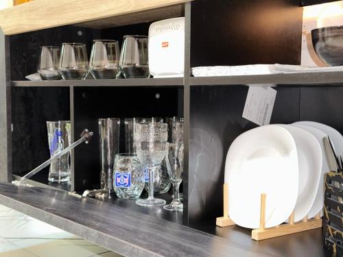 a shelf filled with glasses on a counter at Hedonist Spa Jacuzzi Sarajevo Free parking in Sarajevo