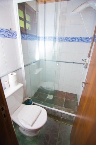 a bathroom with a toilet and a shower at Cabanas Do Araçá Villa in Porto Belo