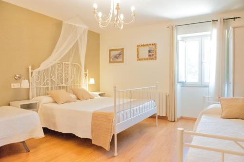 a bedroom with two beds and a chandelier at A Casa do Folgo Turismo Rural in Negreira