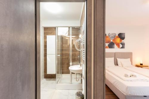 a bedroom with a bed and a bathroom with a sink at Lakeview Apartment Fonyód in Fonyód