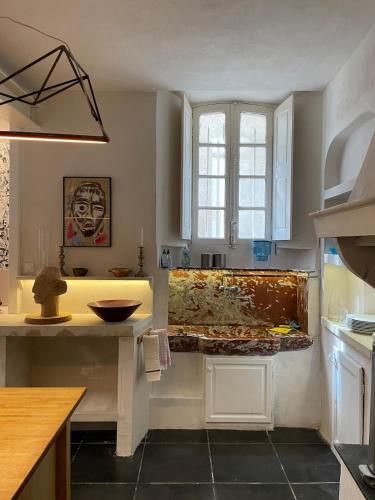 une cuisine avec un évier et un plan de travail dans l'établissement Artist Residence - courtyard, terrace, Grand Piano, à Siran