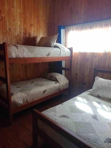 a room with two bunk beds and a window at hermosa casa vacacione en licanray in Trape