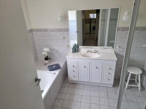a white bathroom with a sink and a tub and a toilet at Mint in Penneshaw