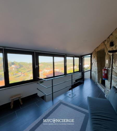 a living room with a large group of windows at Quinta Do Larai in Vale de Cambra