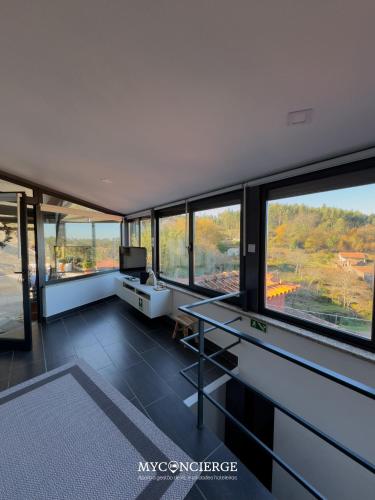 an office with a glass desk and large windows at Quinta Do Larai in Vale de Cambra