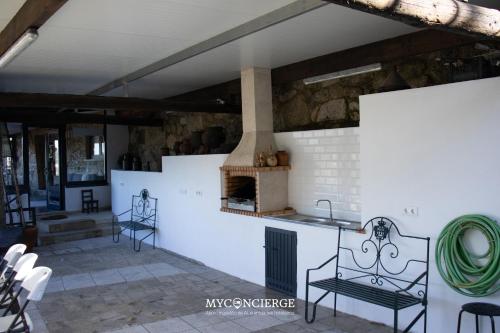 a kitchen with a fireplace and chairs in a room at Quinta Do Larai in Vale de Cambra
