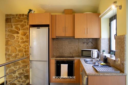 a kitchen with wooden cabinets and a white refrigerator at Quinta Do Larai in Vale de Cambra
