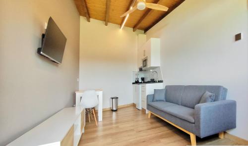 a living room with a blue chair and a kitchen at A Casa do Folgo Turismo Rural in Negreira