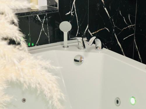 a bathroom with a white sink and a tub at Hedonist Spa Jacuzzi Sarajevo Free parking in Sarajevo