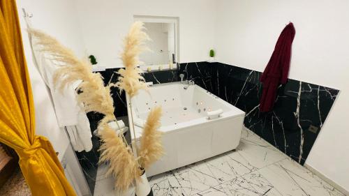 a bathroom with a white tub with feathers on the wall at Hedonist Spa Jacuzzi Sarajevo Free parking in Sarajevo