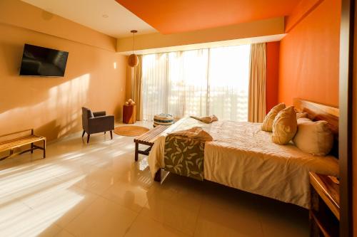 a bedroom with a bed with an orange wall at Hotel Wellness - Belleza y Serenidad in Boca del Río