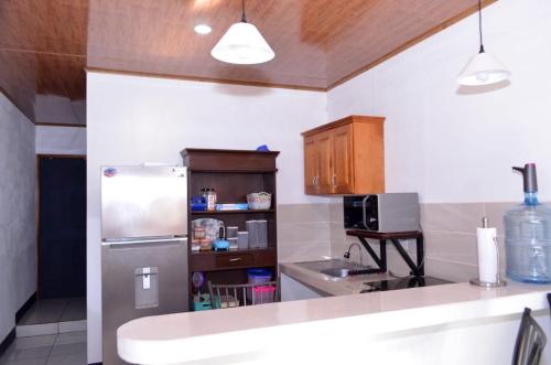 a kitchen with a stainless steel refrigerator and a microwave at Casa Sunshine in Matagalpa