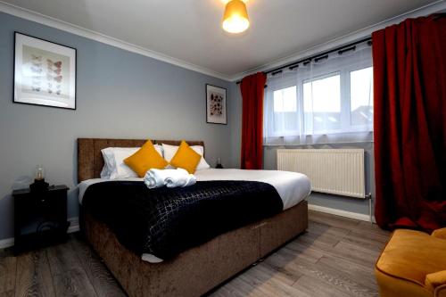 a bedroom with a bed and a window with red curtains at Cozy 2-Bed Detached Bungalow with Parking Woking in Horsell