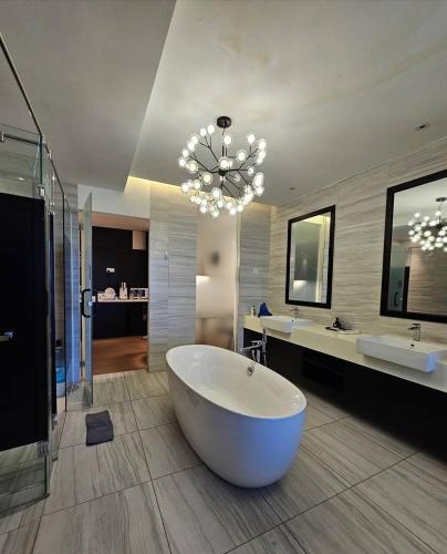 a large bathroom with a large tub and a chandelier at 夜色V8s in Kampong Alor Gajah