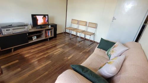 un soggiorno con un divano e una TV di Casa completa a Caçapava do Sul