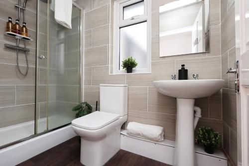 a bathroom with a toilet and a sink and a shower at Cardiff City Guesthouse, Central Rooms, Fast Wi-Fi, On-Street Parking in Cardiff