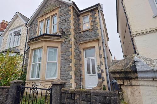 a stone house with a white door and a fence at Cardiff City Guesthouse, Central Rooms, Fast Wi-Fi, On-Street Parking in Cardiff