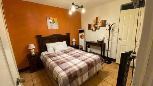a bedroom with a bed with a checkered blanket at Hotel y Restaurante San Fernando. in Jocotenango