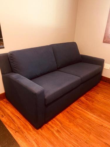 a blue couch in a room with a wooden floor at Luxury Single Level, Great Location, Hot Tub, Arcade in South Lake Tahoe