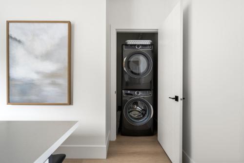 a washing machine in a room next to a door at Mountain Suite, Ocean View Fire Pit, Fully Equipped Kitchen, WD in Nanaimo