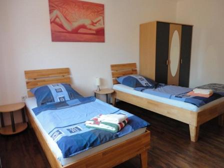 two twin beds in a room with wooden floors at Ferienwohnung Laux in Essen