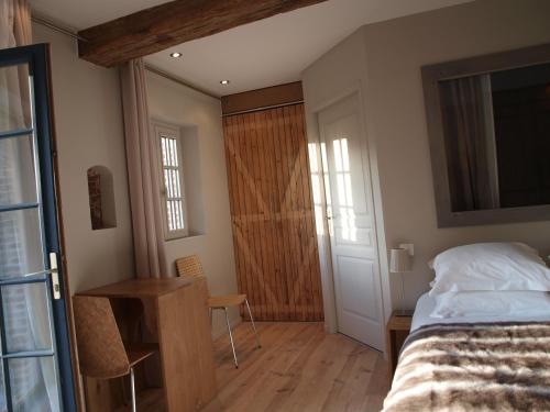 a bedroom with a bed and a wooden floor at Clos Masure hôtel de campagne in Belmesnil